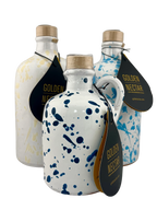 A collection of white ceramics with colored, speckled paint. One with yellow speckles, one with light blue speckles and the other dark blue 