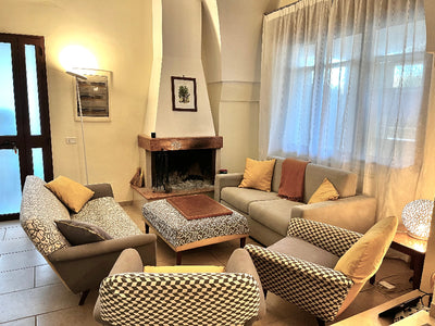 Living room with gray sofa, patterned chairs, and a fireplace.
